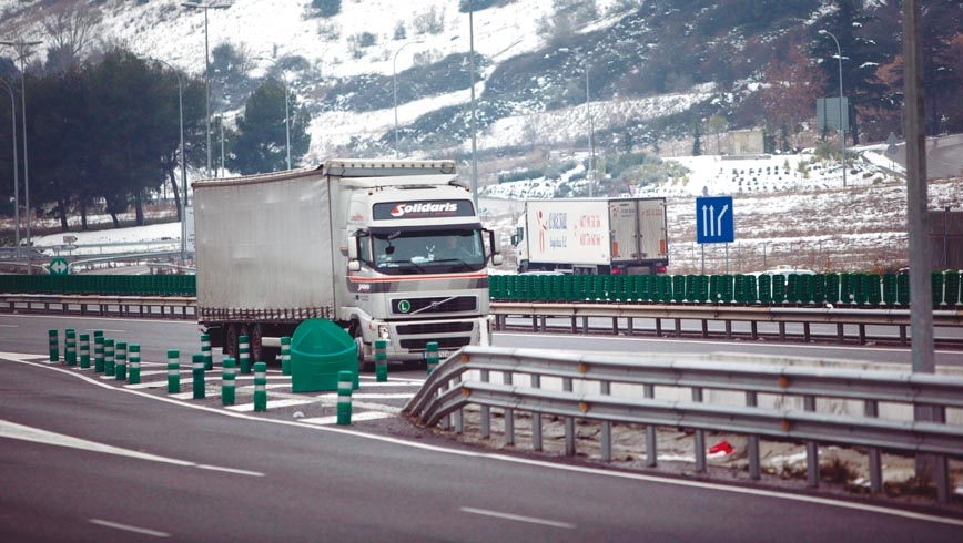 Camión circulando por carretera nevada