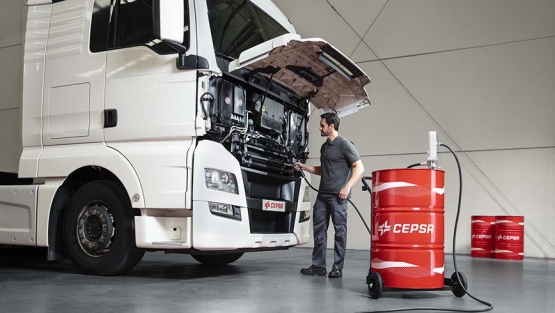 Mecánico trabajando con un camion y lubricantes Cepsa